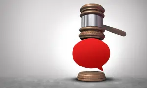 Młotek sędziowski i czerwona dymek symbolizują potencjalne zniesławienie.