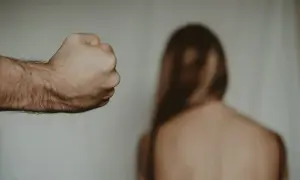 Zaciśnięta pięść mężczyzny grozi kobiecie. Gdzie zgłosić znęcanie psychiczne przez męża? Szukaj pomocy.