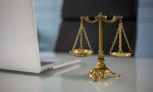 Waga sprawiedliwości i laptop. Czy proces o zniesławienie jest wart wysiłku?