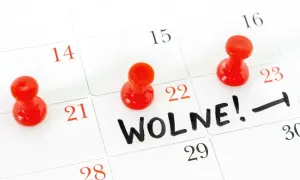Czerwone pinezki zaznaczają dni wolne na kalendarzu. Na 22. dniu widnieje napis "WOLNE!".
