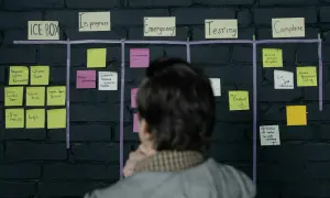 Tablica z zadaniami w stylu blended learning: "ICE BOX", "In progress", "Emergency", "Testing", "Complete". Osoba analizuje postęp prac.