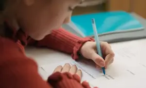 Dziecko pisze test, starając się o dopuszczający ocena.