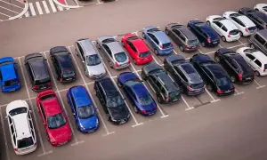 Wiele samochodów na parkingu, zastanawiasz się, czy wybrać prawne rozwiązania parkingowe czy płacić za postój.