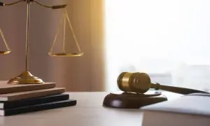 Waga sprawiedliwości, młotek sędziowski i księgi. Kto dziedziczy po mężu? Prawo rozstrzygnie.