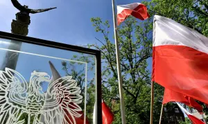 Orzeł biały i polskie flagi na tle nieba. Czy 3 maja można pracować? To pytanie zadają sobie Polacy w święto Konstytucji.