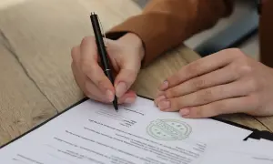Osoba prawna podpisuje dokument, potwierdzając umowę.