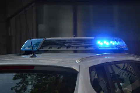 Niebieskie światła policyjne na dachu radiowozu, sygnalizujące dozór policyjny.