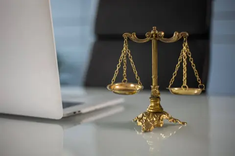Waga sprawiedliwości i laptop. Czy proces o zniesławienie jest wart wysiłku?