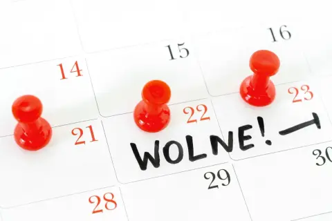 Czerwone pinezki zaznaczają dni wolne na kalendarzu. Na 22. dniu widnieje napis "WOLNE!".