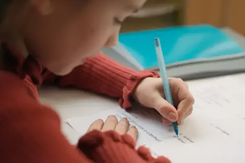 Dziecko pisze test, starając się o dopuszczający ocena.