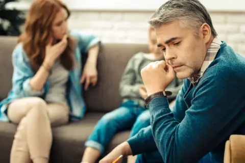 Rodzina w gabinecie terapeuty. Zamyślony ojciec, matka i dziecko. Temat: kontakty z dzieckiem a osoby trzecie.