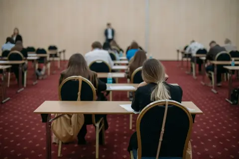 Uczniowie siedzą w rzędach, skupieni na zadaniach. To może być ich szansa na poprawę wyników, czyli matura poprawkowa.