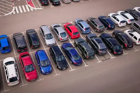 Wiele samochodów na parkingu, zastanawiasz się, czy wybrać prawne rozwiązania parkingowe czy płacić za postój.