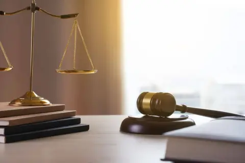 Waga sprawiedliwości, młotek sędziowski i księgi. Kto dziedziczy po mężu? Prawo rozstrzygnie.