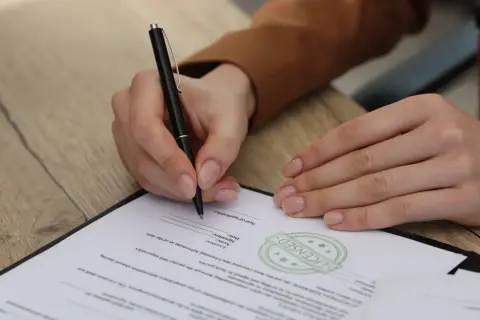 Osoba prawna podpisuje dokument, potwierdzając umowę.