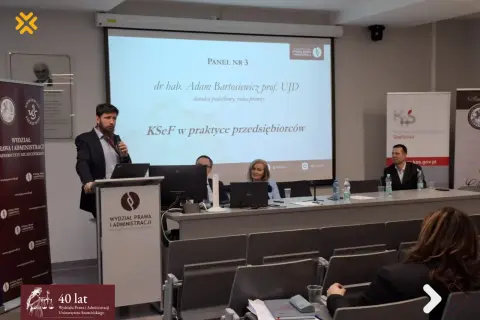 Panel dyskusyjny z prelegentami i prezentacją na ekranie.