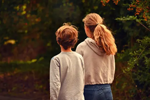 Dwoje dzieci patrzy w dal. Sytuacja sugeruje ograniczenie władzy rodzicielskiej, gdzie dzieci szukają własnej drogi.