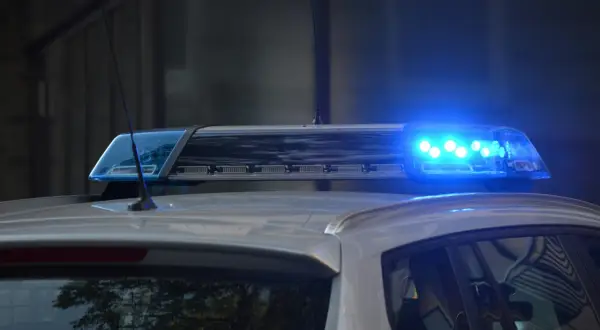Niebieskie światła policyjne na dachu radiowozu, sygnalizujące dozór policyjny.