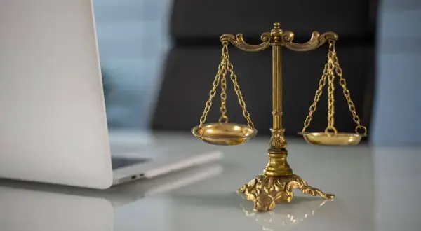 Waga sprawiedliwości i laptop. Czy proces o zniesławienie jest wart wysiłku?