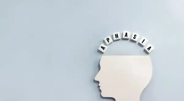 Biały profil głowy z literami tworzącymi napis "APHASIA" nad nim. Symbolizuje to afazję mieszaną, trudności w komunikacji.
