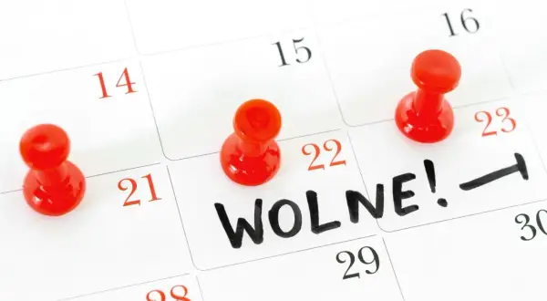 Czerwone pinezki zaznaczają dni wolne na kalendarzu. Na 22. dniu widnieje napis "WOLNE!".