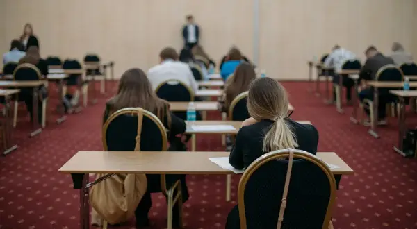 Uczniowie siedzą w rzędach, skupieni na zadaniach. To może być ich szansa na poprawę wyników, czyli matura poprawkowa.