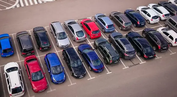 Wiele samochodów na parkingu, zastanawiasz się, czy wybrać prawne rozwiązania parkingowe czy płacić za postój.