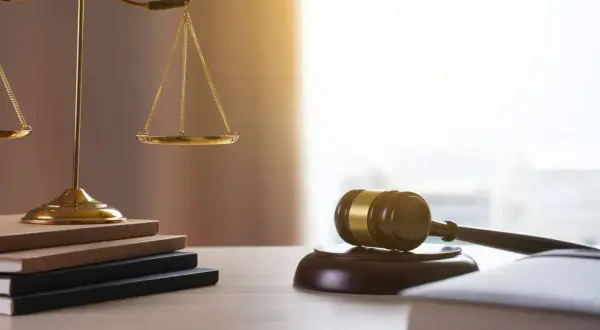 Waga sprawiedliwości, młotek sędziowski i księgi. Kto dziedziczy po mężu? Prawo rozstrzygnie.