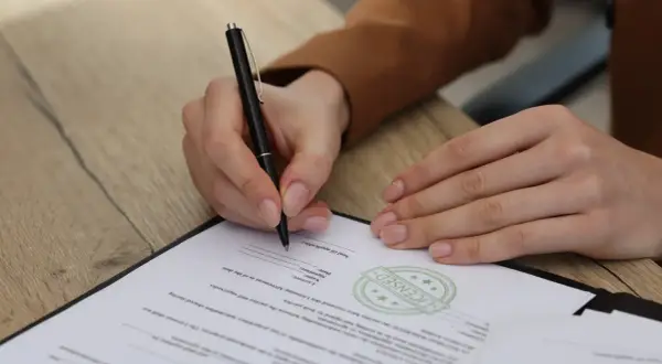 Osoba prawna podpisuje dokument, potwierdzając umowę.