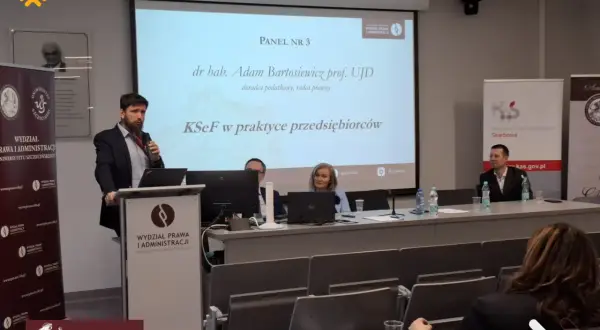 Panel dyskusyjny z prelegentami i prezentacją na ekranie.