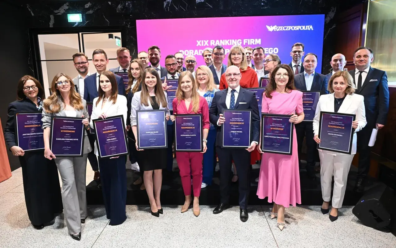 Grupa nagrodzonych osób z dyplomami na tle ekranu z napisem "XIX Ranking Firm Doradztwa Podatkowego".