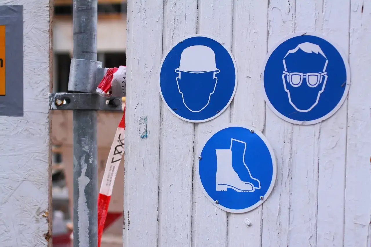 Znaki BHP: kask, okulary, obuwie. Przypominają o obowiązkach pracodawcy, które reguluje Kodeks pracy.