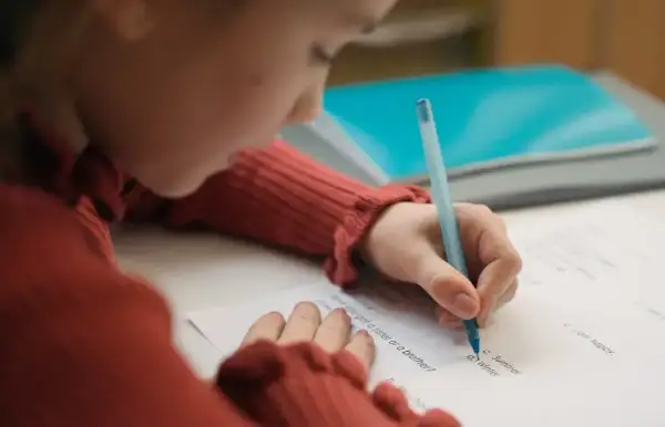 Dziecko pisze test, starając się o dopuszczający ocena.