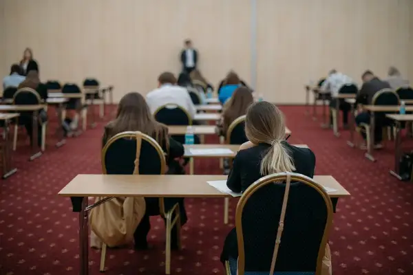 Uczniowie siedzą w rzędach, skupieni na zadaniach. To może być ich szansa na poprawę wyników, czyli matura poprawkowa.