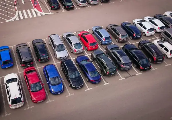 Wiele samochodów na parkingu, zastanawiasz się, czy wybrać prawne rozwiązania parkingowe czy płacić za postój.
