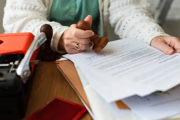 Kobieta stempluje dokument, potwierdzając tytuł prawny do lokalu.